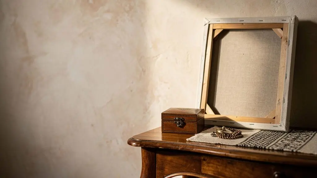 Composition symbolique d'objets de famille précieux protégés dans un intérieur feutré, illustrant la transmission et la protection du patrimoine mobilier